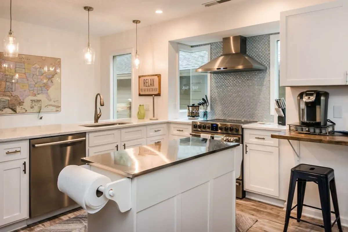 A welcoming kitchen with stainless steel appliances, an island countertop, and a decorative map on the wall. The space is thoughtfully designed for cooking, entertaining, and hosting family gatherings, blending style and practicality.